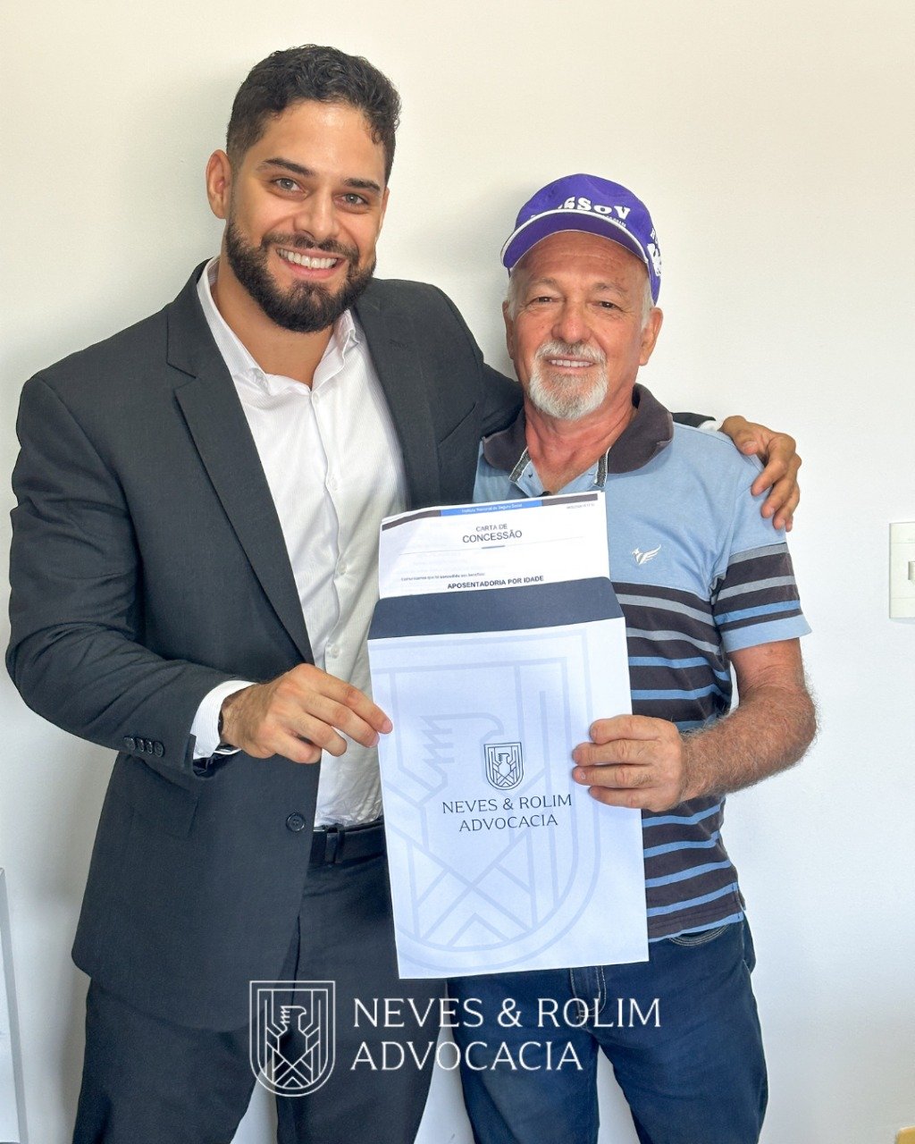 Advogado ao lado de cliente segurando uma carta de concessão de aposentadoria